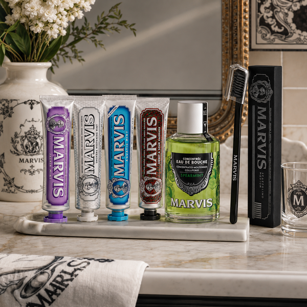 Marvis toothpaste, mouthwash and black toothbrush arranged for a premium oral care routine