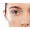 Close-up of a person's eye with a light-colored cream applied to the skin.