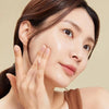 Woman touching her face with a neutral background