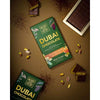 Dubai Chocolate packaging with chocolate pieces and spices on a brown background