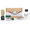 Proraso travel shaving kit set, including a shaving brush, pre-shave cream, shaving cream in a tube, after shave balm, and a bottle of water, all displayed in front of a cardboard box with the Proraso brand and 'Travel Shaving Kit' text.