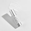 Skincare serum bottle with visible brand name on a light gray background