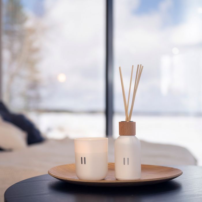 Diffuser and candle on a table with a blurred background