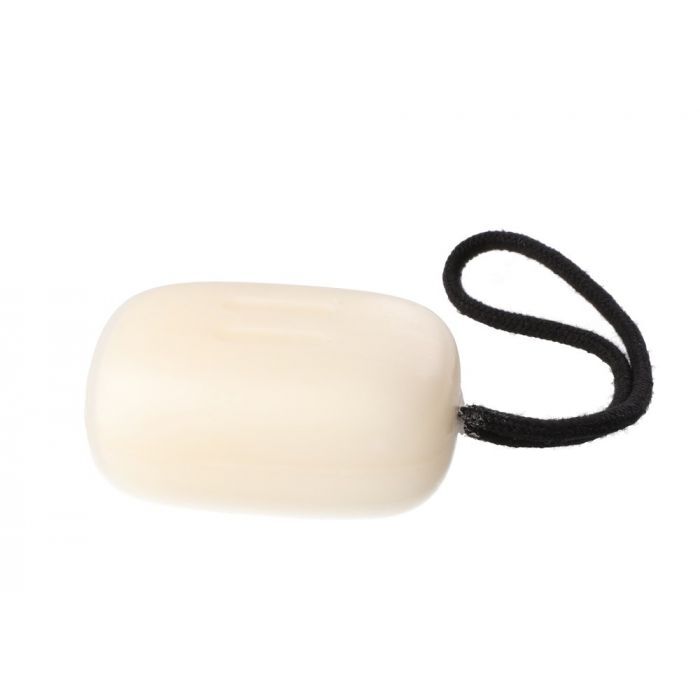 White soap bar with a black rubber band on a white background