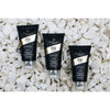A travel set of DSD de Luxe hair care products including shampoo, hair mask, and hair serum, packaged in black tubes with gold and white accents