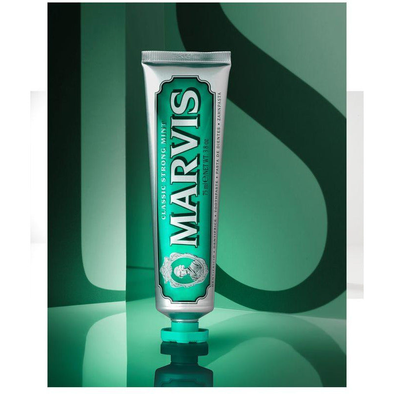 A tube of Marvis Classic Strong Mint toothpaste with a green label and white branding text.