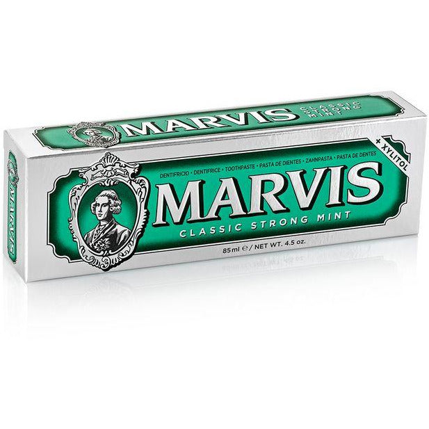 A tube of Marvis Classic Strong Mint toothpaste with a green label and white branding text.